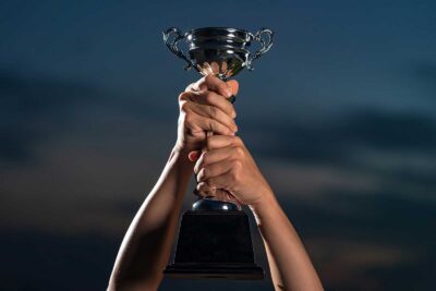 Male arms holding up a trophy for the best dispensaries near me in Vancouver.